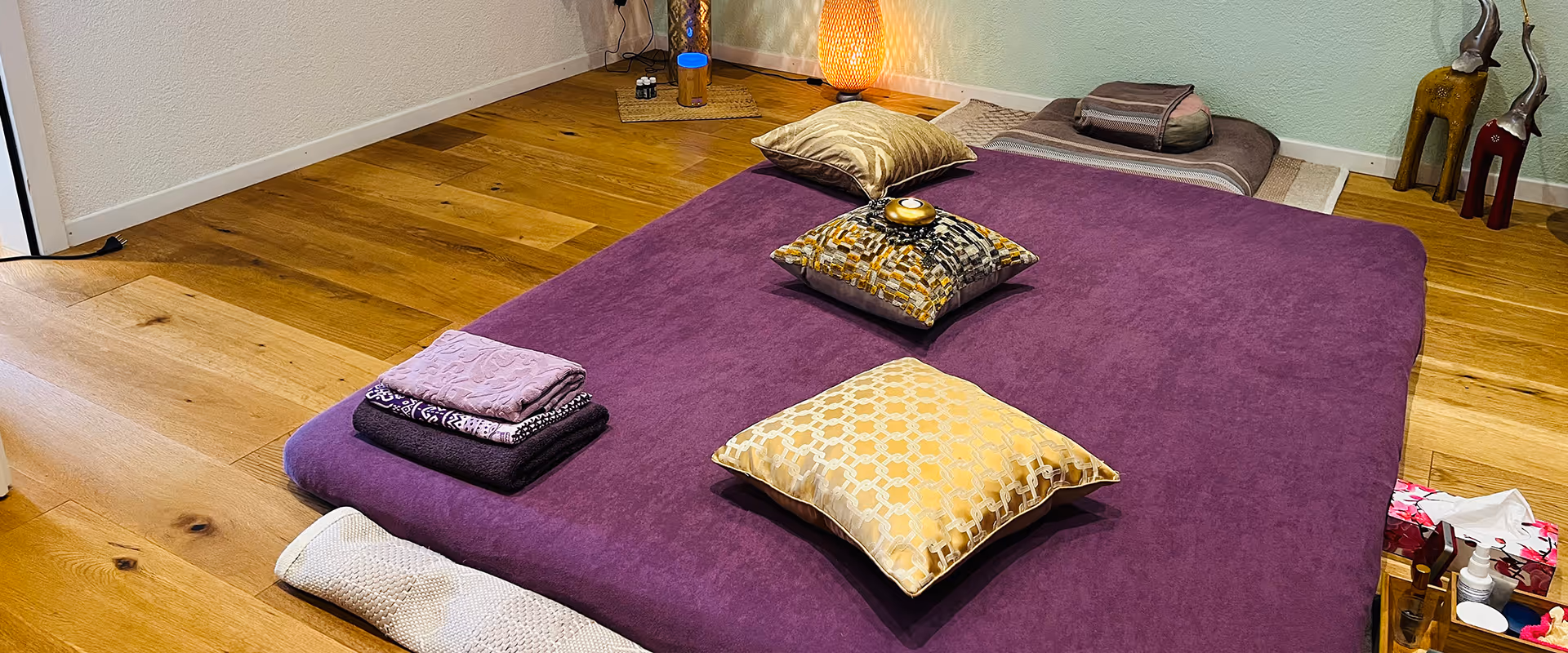 Practice room of Veronika Mutti in Zurich-Altstetten with purple massage mat, cushions and warm wooden floor