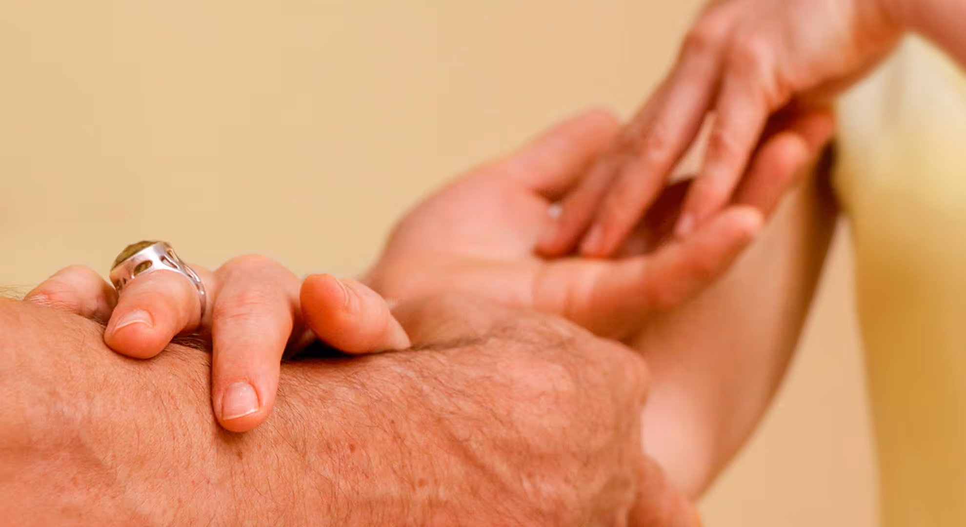 Two hands touching gently symbolise connection and care for the Tantra massage course