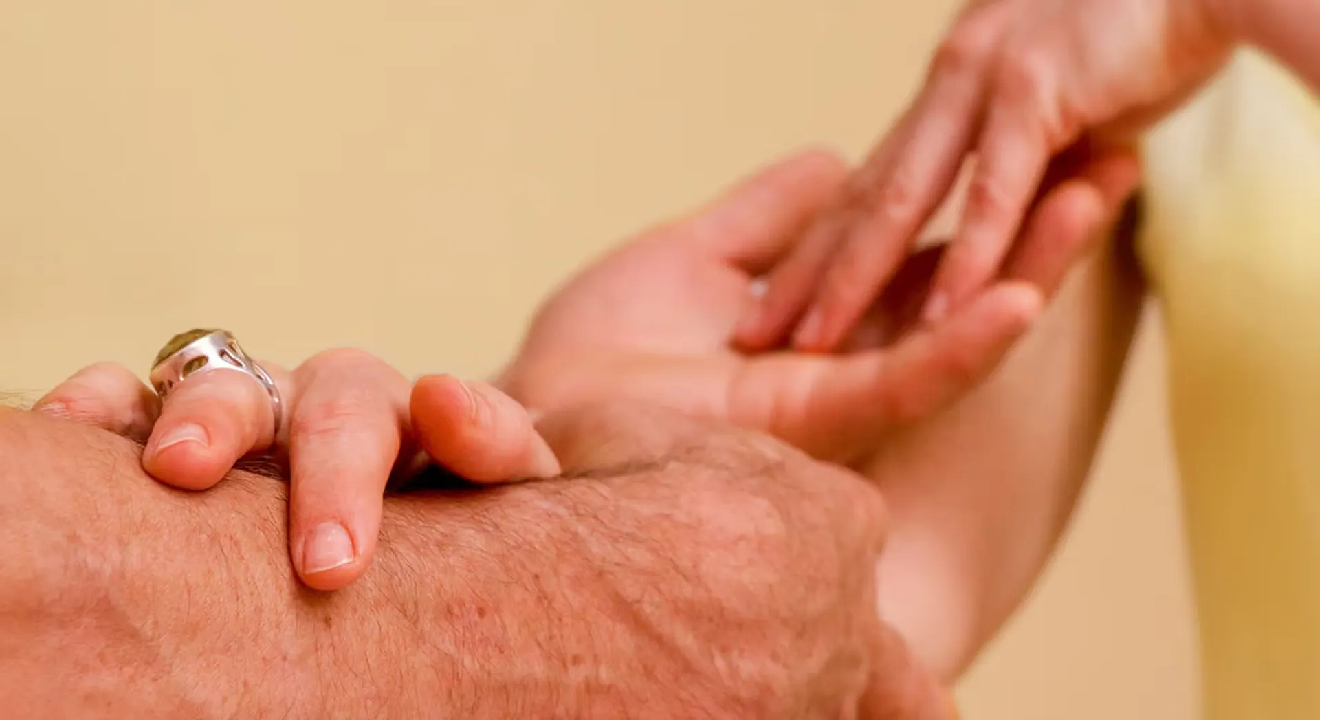 Two hands touching gently symbolise connection and care for the Tantra massage course